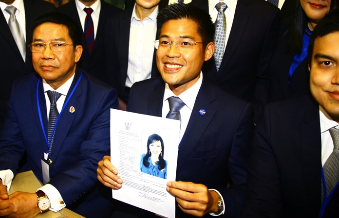 Leader of Thai Raksa Chart party PreechaPholphongpanich, center, holds a picture of Princess Ubolratana at election commission of Thailand in Bangkok, Thailand, Friday, Feb. 8, 2019. The political party has selected the princess as its nominee to serve as the next prime minister, upending tradition that the royal palace plays no public role in politics and upsetting all predictions about what may happen in the March election. (AP Photo)