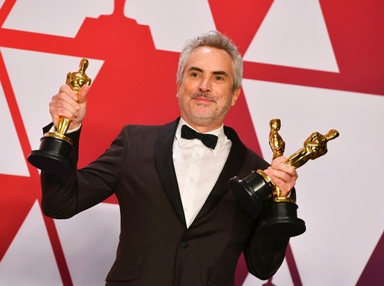 Alfonso Cuaron poses with the awards for best director, best foreign language film, and best cinematography for the film “Roma” at the Oscars ceremony, Sunday, Feb. 24. (Photo by Jordan Strauss/Invision/AP)