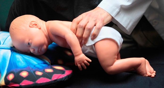 In this March 22, 2012 file photo, a doctor demonstrates how an infant can die due to unsafe sleeping practices using a scene re-enactment doll in Norfolk, Va. Released on Monday, April 22, 2019, an analysis of five years of CDC data found most accidental suffocation deaths in U.S. infants occur when babies are sleeping on their stomachs in adult beds with blankets and pillows. (AP Photo/The Virginian-Pilot, Steve Earley, File)