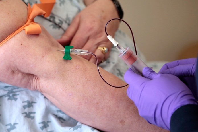In this Tuesday, April 28, 2015 file photo, a patient has her blood drawn at a hospital in Philadelphia to monitor her cancer treatment. Companies are trying to develop blood tests that can look for signs of many types of cancer at once. (AP Photo/Jacqueline Larma, File)