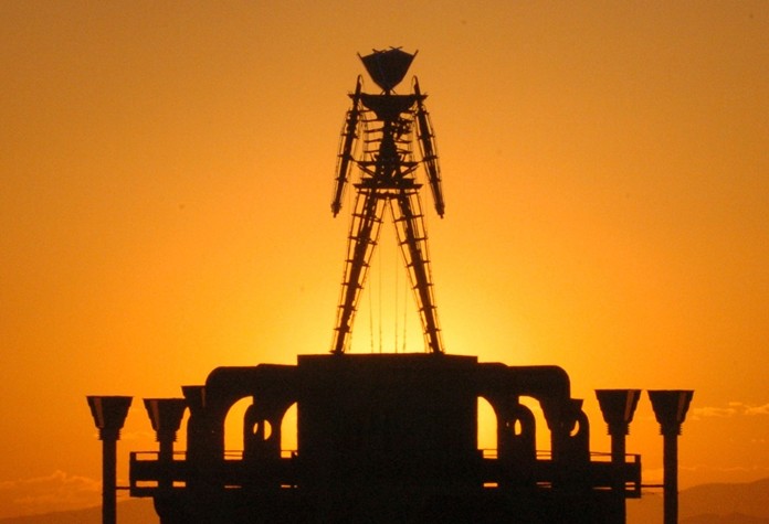 "The Man," a stick figured symbol of the Burning Man art festival, is silhouetted against a morning sunrise in Nevada's Black Rock Desert. (AP Photo/Ron Lewis)