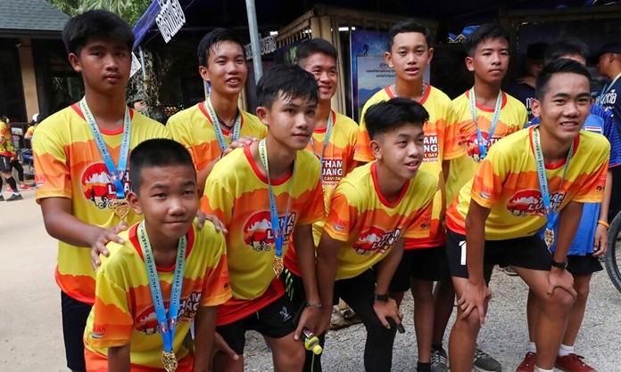 Members of the Wild Boars soccer team who were rescued from a flooded cave, pose for the media after a marathon and biking event in Mae Sai, Chiang Rai province, Thailand, Sunday, June 23, 2019. (AP Photo/Sakchai Lalit)