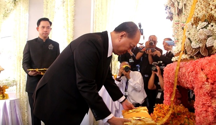 As former Pattaya Mayor Itthiphol Kunplome looks on, Interior Minister Anupong Paochinda makes merit before a parade of dignitaries pay their last respects to Somchai Kunplome, patriarch of Chonburi’s political dynasty.