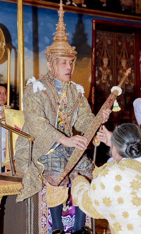 His Majesty King Maha Vajiralongkorn receives one of the many items of investiture including the royal golden plaque upon which is inscribed his royal official title, together with the royal seal of state, the royal regalia, the royal utensils, and the weapons of sovereignty.