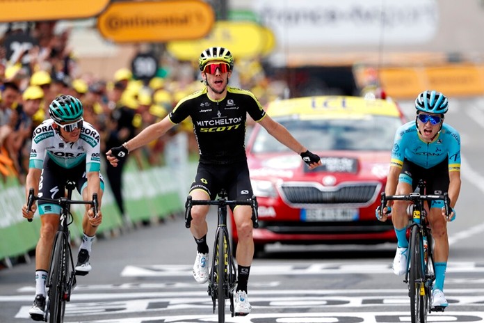 Britain's Simon Yates, center, surrounded by Spain's Pello Bilbao Lopez De Armentia, right, and Austria's Gregor Muhlberger, celebrates as he crosses the finish line to win the twelfth stage of the Tour de France cycling race in Bagneres-de-Bigorre, France, Thursday, July 18, 2019. (AP Photo/ Thibault Camus)