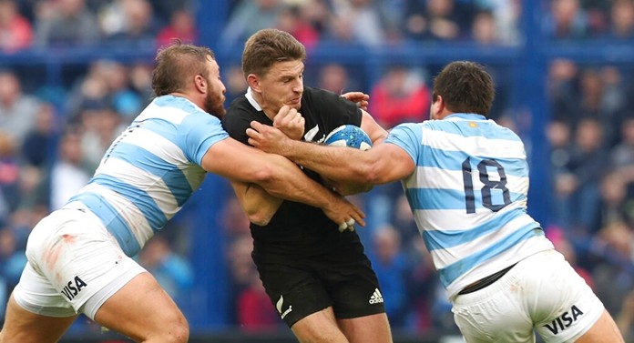 New Zealand's All Blacks Beauden Barrett center, is tackled by Argentina's Los Pumas Santiago Medrano, right, and Mayco Vivas, during a rugby championship match in Buenos Aires, Argentina, Saturday, July 20, 2019. (AP Photo/Natacha Pisarenko)