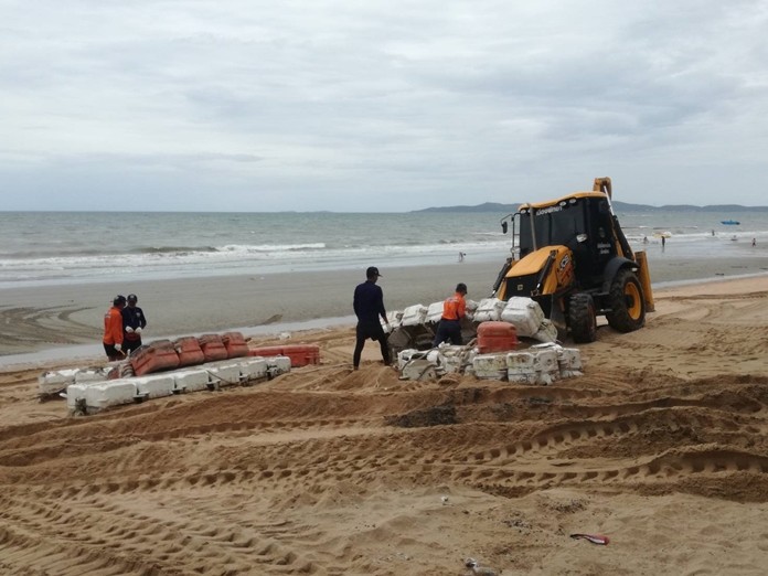 Environment Department workers collect swimming-area buoys damaged by recent storms along Jomtien Beach.