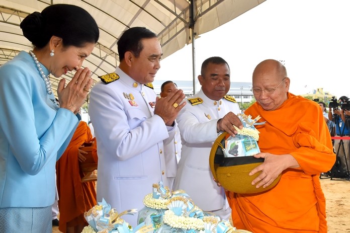 Prime Minister Gen. Prayut Chan-o-cha together with his wife, Naraporn offer alms to Buddhist monks.