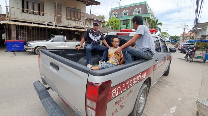 39-year-old Mr. Jarat Injom is hauled off to the police station.  