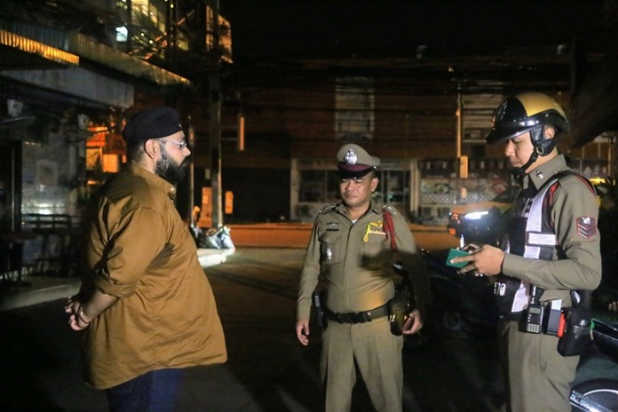 Aman Preet Bagga (left) talks to police officers after his gold necklace was stolen on August 1 in central Pattaya.