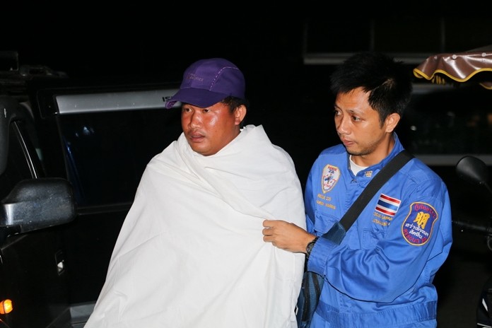 Kompetch Jansorn, left, is assisted by one of his rescuers as he lands ashore following his 8-hour ordeal at sea.