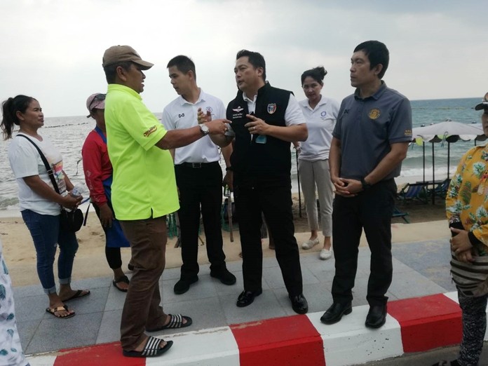 Chief of Special Tasks Komkrit Polwichid, along with Pattaya government officials and law enforcement visit the disgruntled beach vendors and promise to remedy the situation.