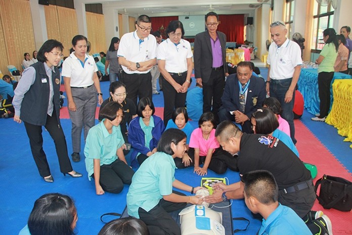 Rotarians and students watch intensely as Naval Captain Bunlue Buasomboon explains the proper method of CPR and use of the AED to one of the students.