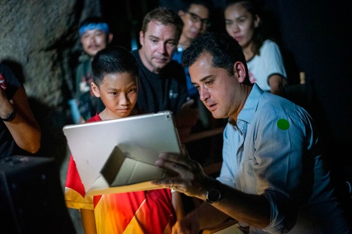 In this Nov. 14, 2018, photo provided by De Warrenne Pictures, director Tom Waller, right, talks to actors for a scene of his film "The Cave" in Thailand. (De Warrenne Pictures via AP)