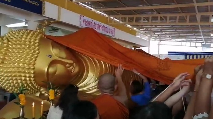 People provide a new robe for the reclining Buddhasaiyad Rachasanmingmongkol at Wat Nong Aor Monastery.