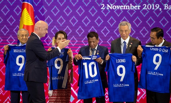 FIFA president Gianni Infantino, second left, claps as ASEAN leader from left, Malaysia Prime Minister Mahathir Mohamad, Myanmar State Counsellor Aung San Suu Kyi, Philippines President Rodrigo Duterte, Singapore Prime Minister Lee Hsien Loong and Thailand Prime Minister Prayuth Chan-ocha hold soccer jerseys with their names during a ceremony to signing of memorandum of understanding between The ASEAN and FIFA in Nonthaburi, Thailand, Saturday, Nov. 2, 2019. (AP Photo/Sakchai Lalit)