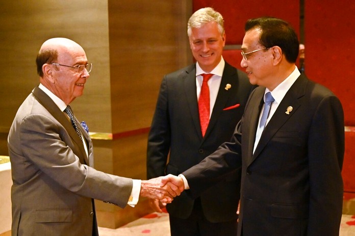 U.S. Commerce Secretary Wilbur Ross, left, shakes hands with China's Premier Li Keqiang, right, as U.S. National Security advisor Robert O'Brien watches during a bilateral meeting in Bangkok, Thailand Monday, Nov. 4, 2019, on the sidelines of the 35th Association of Southeast Asian Nations (ASEAN) summit. (Romeo Gacad/Pool Photo via AP)