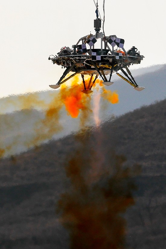 A lander is lifted during a test of hovering, obstacle avoidance and deceleration capabilities at a facility in Huailai in China’s Hebei province, Thursday, Nov. 14, 2019. (AP Photo/Andy Wong)