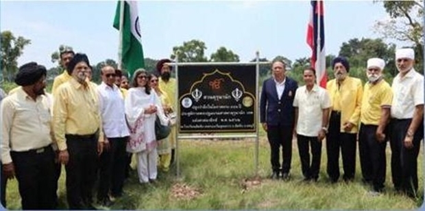 The Indian group stands by a sign erected to commemorate the tree-planting undertakings.