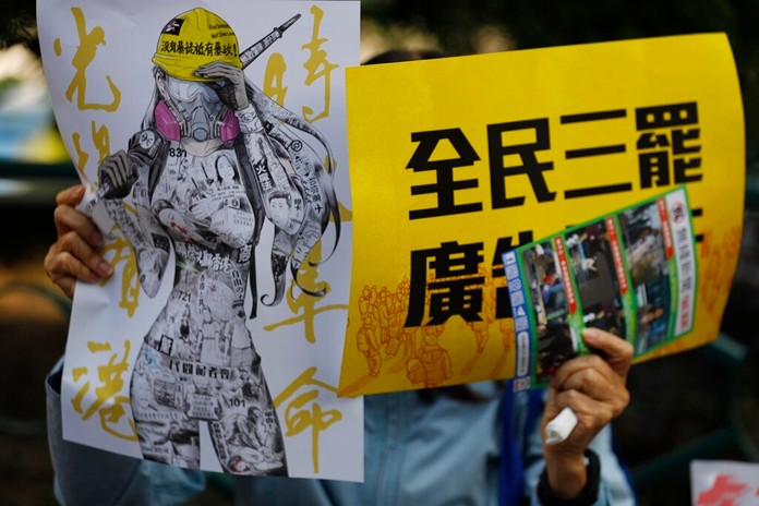 An anti-government supporter holds up banners during a rally by the advertising industry in Hong Kong on Monday, Dec. 2, 2019. (AP Photo/Vincent Thian)
