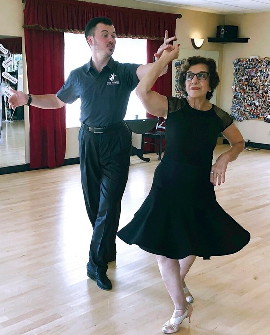 In this Oct. 7, 2019, photo, dance instructor Ned Pavlovic, a native of Serbia, teaches his student Rouhy Yazdani, a native of Iran who now lives in Milford, Conn., some ballroom dance moves at the Fred Astaire Dance Studio in Orange, Conn. (AP Photo/Susan Haigh)