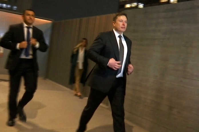 In this frame grab from video, Tesla CEO Elon Musk leaves court, Tuesday, Dec. 3, 2019, in Los Angeles. Musk denied that he meant to call a British cave diver a pedophile when he dubbed him "pedo guy" on social media. (AP Photo/Krysta Fauria)