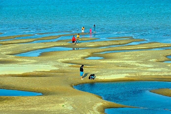 Sightseers play on a sandbar in the Mekong River in Nakhon Phanom province, northeastern Thailand Wednesday, Dec. 4, 2019. (AP Photo/Chessadaporn Buasai)