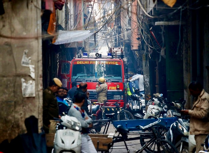 A fire engine stands by the site of a fire in an alleyway, tangled in electrical wire and too narrow for vehicles to access, in New Delhi, India, Sunday, Dec. 8, 2019. (AP Photo/Manish Swarup)