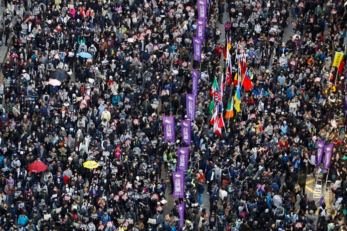 Pro-democracy protesters carry countries' flags as they march on a street in Hong Kong, Sunday, Dec. 8, 2019. (AP Photo/Vincent Thian)