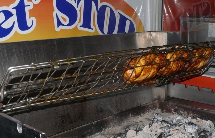 A large BBQ rotisserie with chickens undergoing their 24-hour slow roasting.