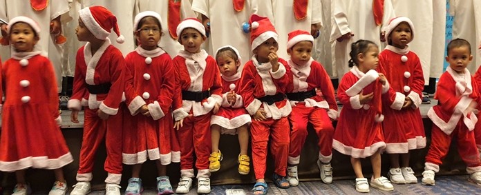Even the youngest, decked out in miniature Santa dress, enjoyed participating with the older children in the Christmas festivities at the PCEC.