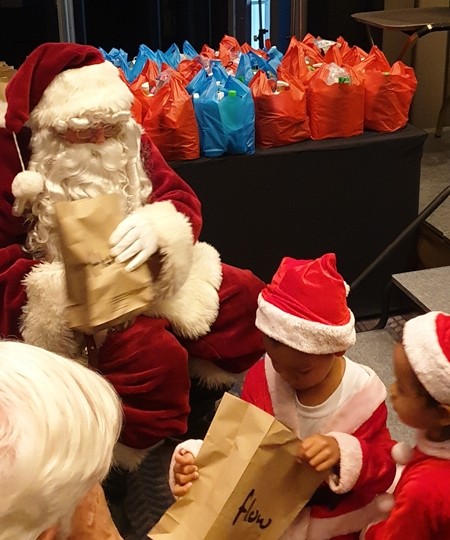 What did Santa bring me seems to be the thoughts as this young choir member looks into his gift sack.