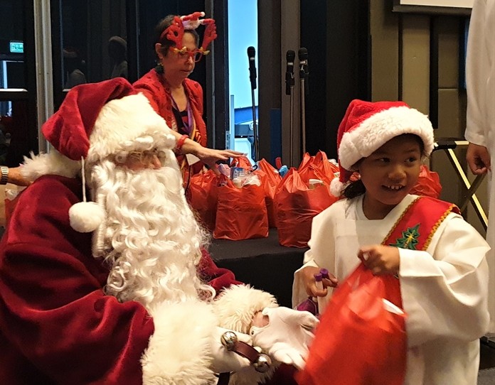 A happy smile as this young lady receives her Christmas present from Santa.