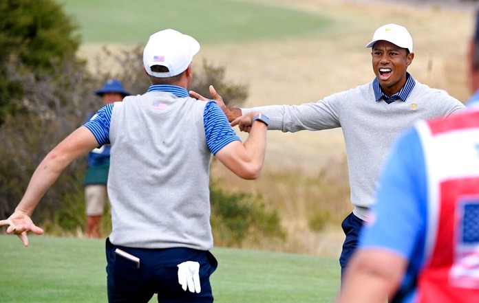 U.S. team player Justin Thomas, left, celebrates with his playing partner and captain, Tiger Woods, on the 18th green in their foursomes match during the President's Cup golf tournament at Royal Melbourne Golf Club in Melbourne, Friday, Dec. 13, 2019. (AP Photo/Andy Brownbill)