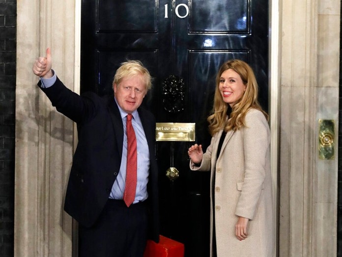 Britain's Prime Minister Boris Johnson and his partner Carrie Symonds wave from the steps of number 10 Downing Street in London, Friday, Dec. 13, 2019. (AP Photo/Matt Dunham)
