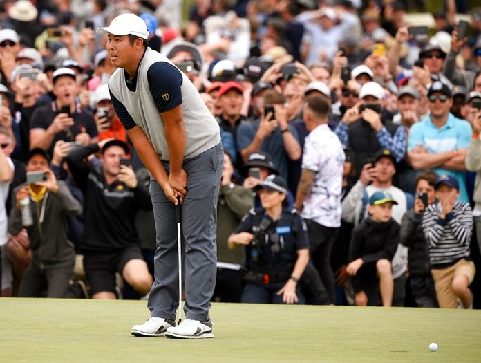 International team player Byeong Hun An of South Korea leans on his putter after missing a putt the 18th green that would have won the their foursome match. (AP Photo/Andy Brownbill)