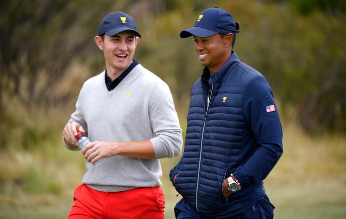 U.S. team player and captain Tiger Woods, right, chats with his player Patrick Cantlay as they walk on the 15th hole during a foursome match. (AP Photo/Andy Brownbill)