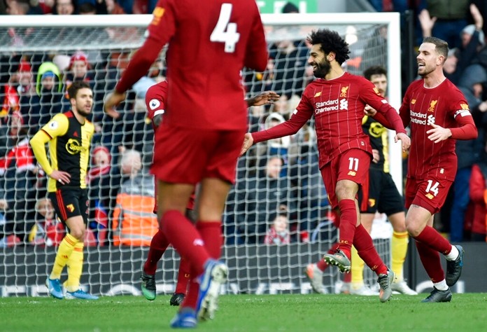 Liverpool's Mohamed Salah, 2nd right, celebrates with teammates after scoring his sides first goal during the English Premier League soccer match between Liverpool and Watford at Anfield stadium in Liverpool, England, Saturday, Dec. 14, 2019. (AP Photo/Rui Vieira)