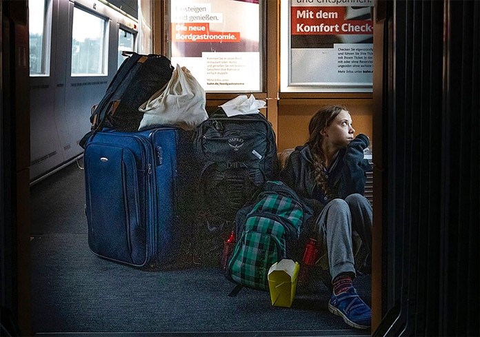 In this image taken from Twitter feed of Climate activist Greta Thunberg, showing Thunberg sitting on the floor of a train surrounded by bags Saturday Dec. 14, 2019, with the comment “traveling on overcrowded trains through Germany. And I’m finally on my way home!” (Twitter @GretaThunberg via AP)