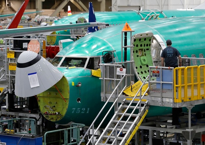 In this March 27, 2019, file photo, a worker enters a Boeing 737 MAX 8 airplane during a brief media tour of Boeing's 737 assembly facility in Renton, Wash. (AP Photo/Ted S. Warren, File)