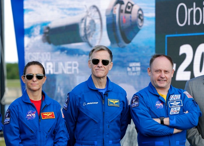 NASA astronaut Nicole Mann, left, Boeing astronaut Chris Ferguson, center, and NASA astronaut Mike Fincke stand in front of the countdown clock during a press conference at the Kennedy Space Center, in Cape Canaveral, Fla., Thursday, Dec. 19, 2019. (AP Photo/Terry Renna)