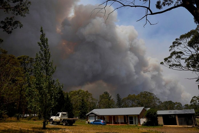 A home stands as smoke from the Grose Valley fire rises in the distance in Bilpin, west of Sydney, Saturday, Dec. 21, 2019.(AAP Image/Dan Himbrechts) 