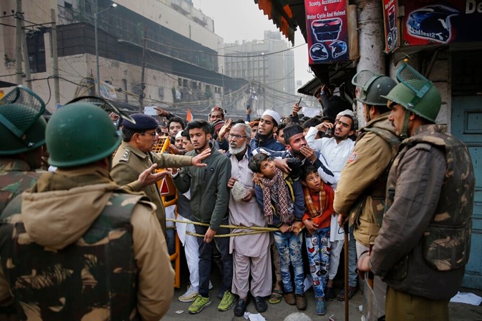 Indian policemen stop protesters at a police barricade in New Delhi, India, Friday, Dec. 20, 2019. (AP Photo/AltafQadri)
