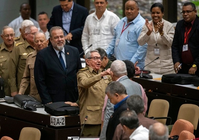 Raul Castro, center, First Secretary of the Communist Party and former president talks with the member of the assembly while Cuban Prime Minister Manuel Marrero Cruz, center left, looks on during the closing session at the National Assembly of Popular Power in Havana, Cuba, Saturday, Dec. 21, 2019. (AP Photo/Ramon Espinosa)