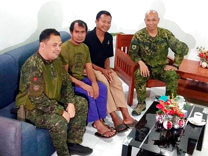 Rescued Indonesians MaharudinLunani, second from left, and Samion Bin Maniue, second from right, pose with Major General CorletoVinluan, center, commander joint task force Sulu, in Jolo, Sulu, southern Philippines on Sunday Dec. 22, 2019.(Armed Forces of the Philippines, Western Mindanao Command via AP)