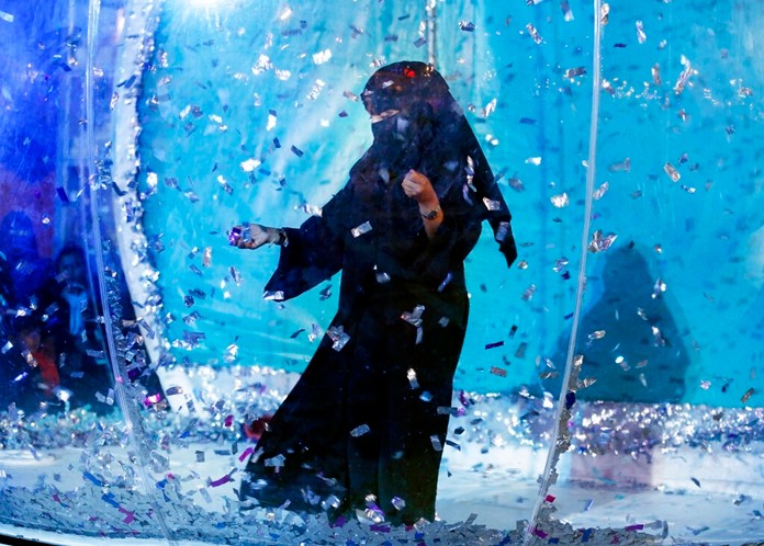 In this Dec. 13, 2019 photo, a woman collects silver tickets as she plays at an amusement park during the Diriyah festival in Diriyah on the outskirts of Riyadh, Saudi Arabia. (AP Photo/Amr Nabil)