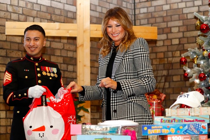 In this Dec. 4, 2019, file photo first lady Melania Trump joins local students and U.S. Marines stationed at the U.S. Embassy, wrapping holiday presents to be donated to the Salvation Army, at the Salvation Army Clapton Center in London. (AP Photo/Alastair Grant, Pool, File)