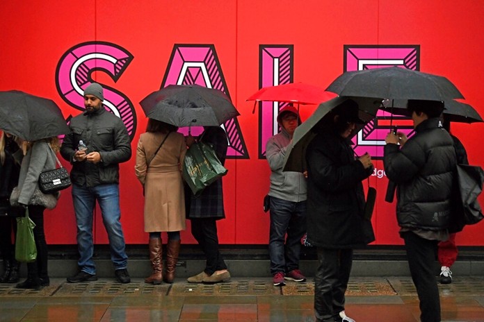Customers queue in the rain ahead of the Selfridges sales in London, Thursday Dec. 26, 2019, as the traditional post-Christmas sales begin. (Kirsty O'Connor/PA via AP)