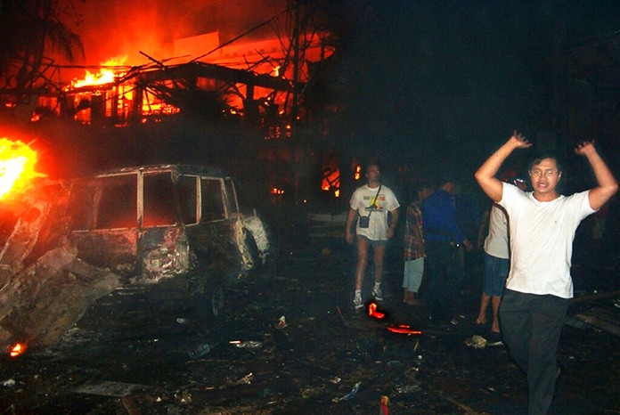 In this Oct. 13, 2002 file photo, residents and foreign tourists evacuate the scene of a bomb blast in Bali, Indonesia.