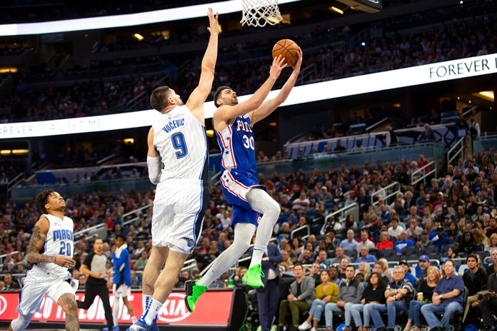 Philadelphia 76ers guard Furkan Korkmaz (30) attempts to lay up the ball against Orlando Magic center Nikola Vucevic (9) during the first half of an NBA basketball game in Orlando, Fla., Friday, Dec. 27, 2019. (AP Photo/Willie J. Allen Jr.)